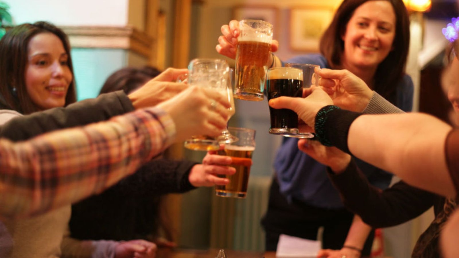 A Group of People Toasting in Pub